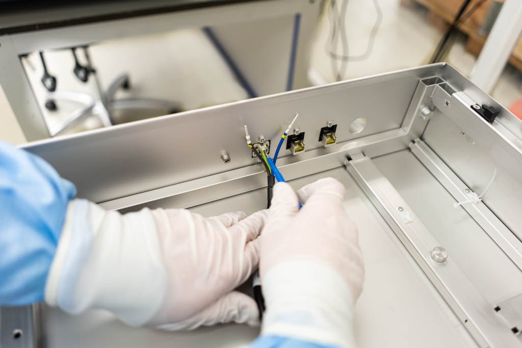 Handen monteren elektrische bedrading in een plaatwerk behuizing